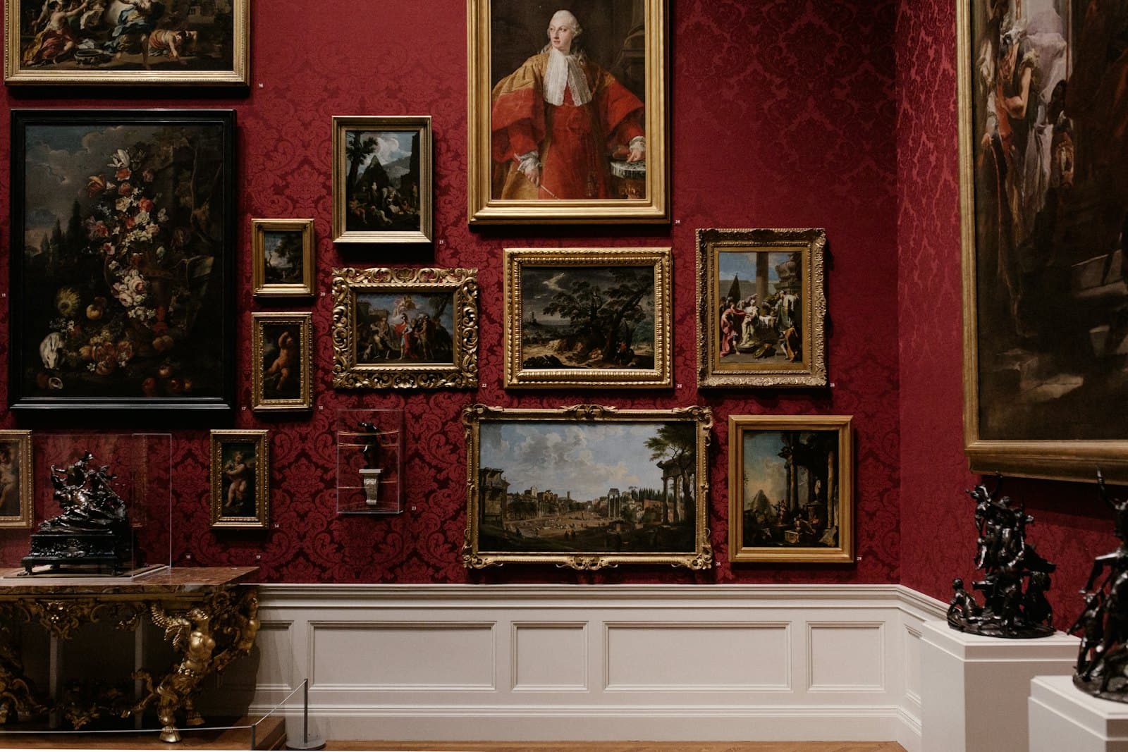 赤い壁に額装作品が並ぶ展示室